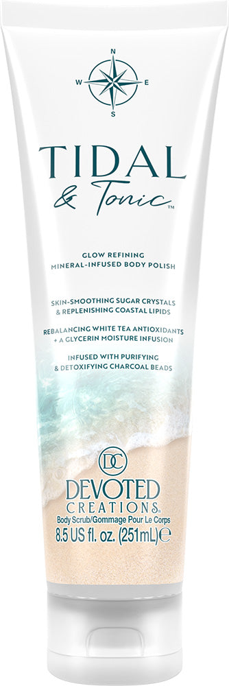 A white tube of Devoted Creations Tidal & Tonic Glow Refining Mineral Infused Body Polish with beach graphics on the lower half, set against a plain white background.