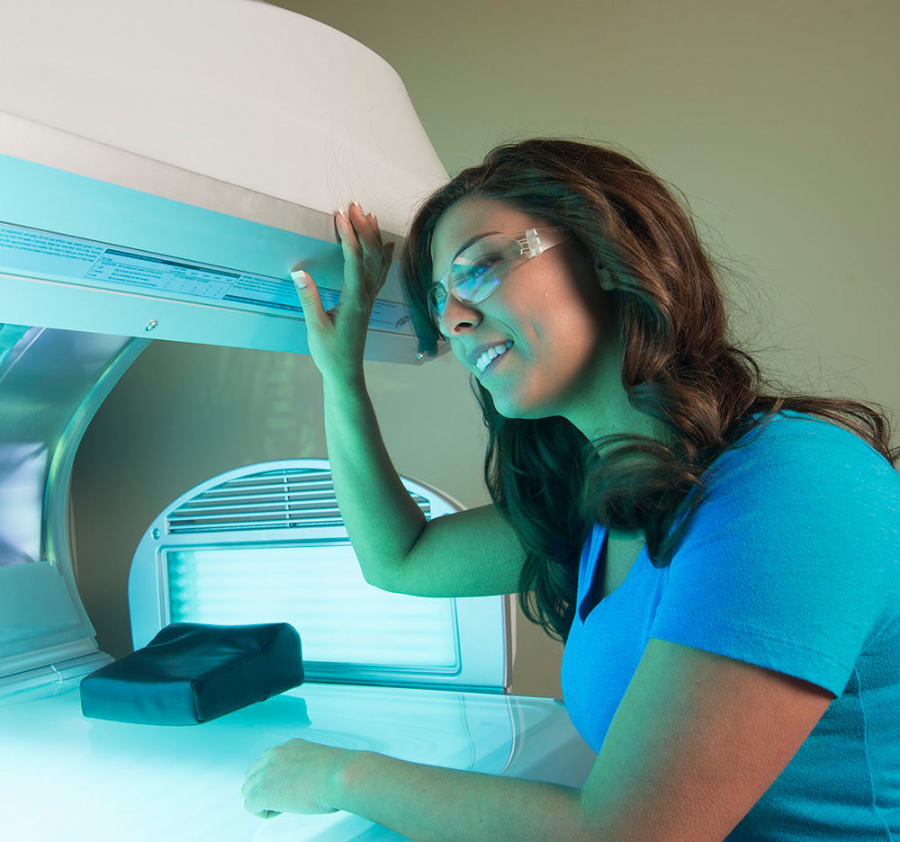 Woman wearing protective eyewear while looking in a tanning bed