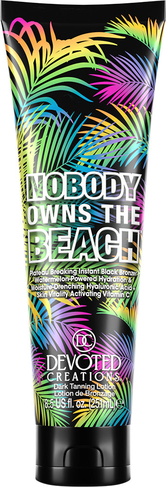 A tube of Devoted Creations 'Nobody Owns the Beach' black tanning lotion with a vibrant, multicolored tropical palm leaf pattern on the packaging.
