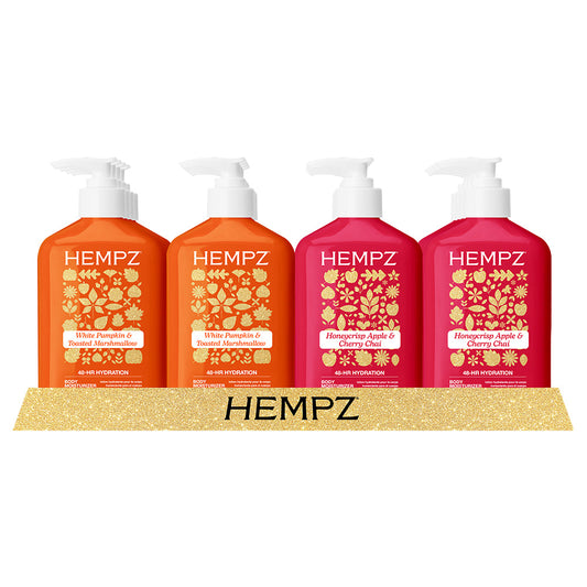 Four bottles of Hempz body wash on a gold platform with 'Hempz' branding.