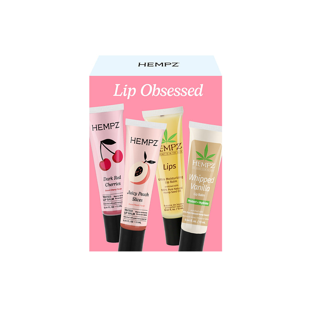 Hempz lip balm set with four tubes on a pink background