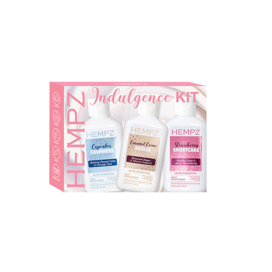Hempz Indulgence Kit containing three bottles: Cucumber Carminative, Caramel Cream Roulee, and Strawberry Shortcake Roulee, presented in a pink and white box.