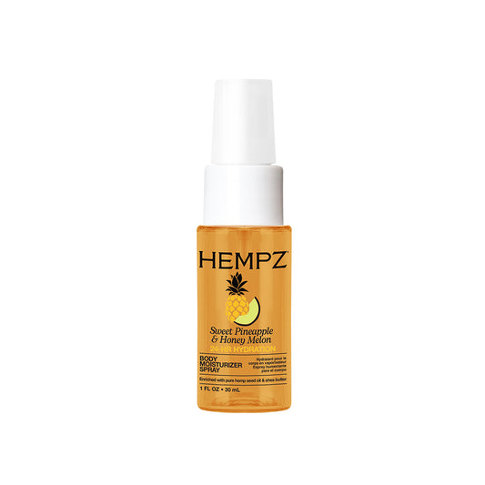 A bottle of HEMPZ Sweet Pineapple & Honey Melon 24 hour hydration body spray, featuring a clear amber bottle showing the golden-yellow liquid inside, a white spray nozzle, and a black label with a pineapple graphic.