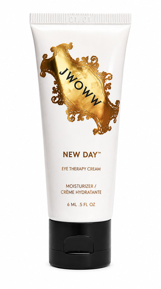 A white squeeze tube of Jwoww New Day Eye Therapy Cream with a black flip-top cap, featuring a prominent gold baroque-style emblem on the front.