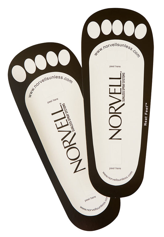 Two Norvell sunless tanning neat feet on a white background
