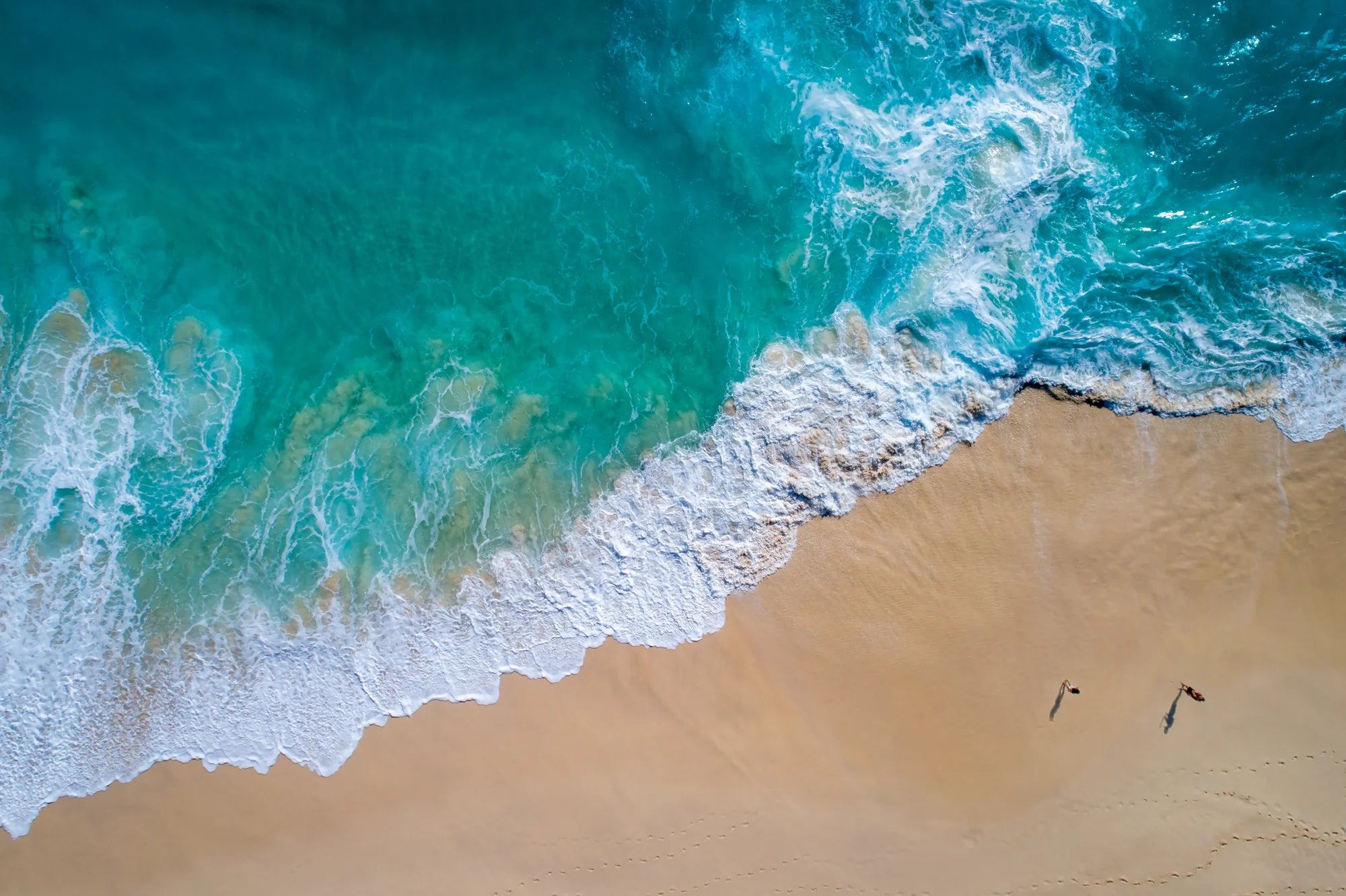 Aerial view of waves crashing onto a sandy beach